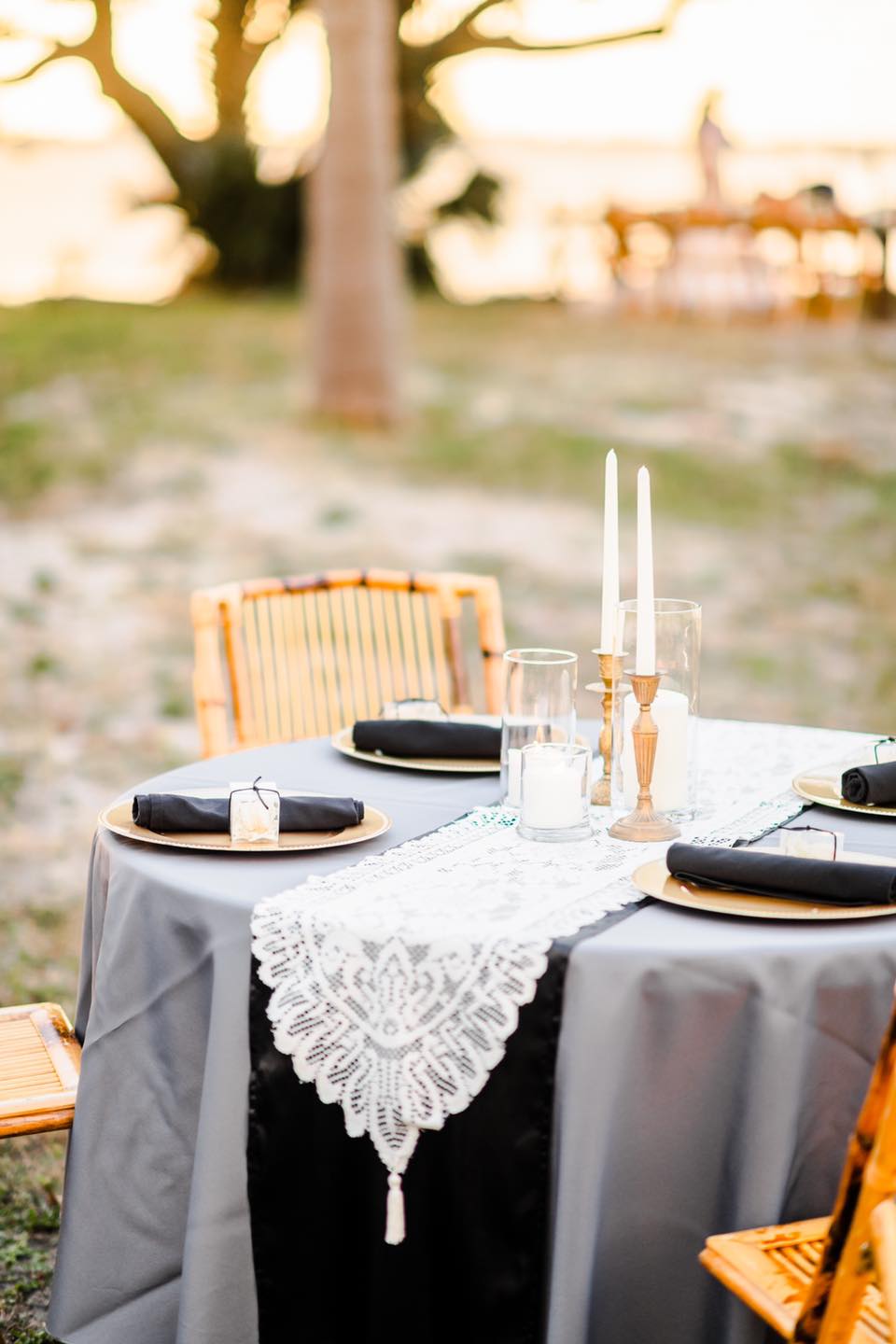 grey, black, and gold wedding place settings with lace table runner
